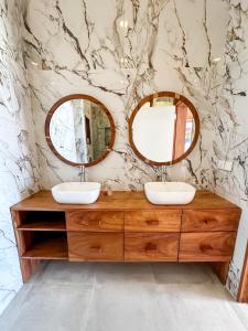 a bathroom with two sinks and two mirrors at Just Heaven Apartments in Matemwe