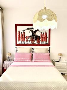 ein Schlafzimmer mit einem großen weißen Bett mit rosa Kissen in der Unterkunft LA MIMOSA 2 in Marina di Bibbona