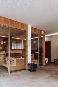 Habitación con paredes de madera y puertas de cristal. en FORSTAUERWiRT Hotel & Restaurant, en Forstau