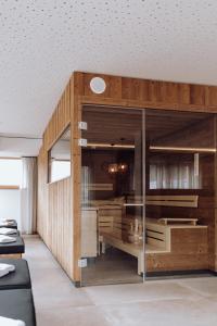 una sala de estar con una gran pared de madera. en FORSTAUERWiRT Hotel & Restaurant, en Forstau