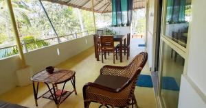 Cette chambre dispose d'un balcon avec des chaises et une table. dans l'établissement BLUE SOPHY Residency, à Varkala