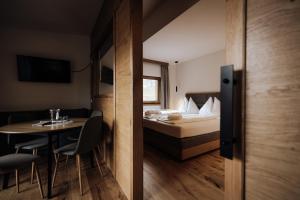 Habitación con cama, mesa, cama, mesa y sillas. en FORSTAUERWiRT Hotel & Restaurant, en Forstau