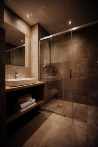 y baño con lavabo y ducha acristalada. en FORSTAUERWiRT Hotel & Restaurant, en Forstau