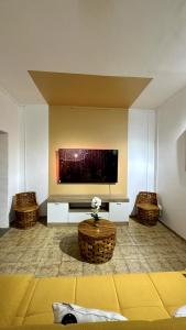 Studio Loulou, Tsoundzou2 في Mamoudzou: غرفة معيشة مع تلفزيون بشاشة مسطحة على جدار