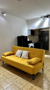 Studio Loulou, Tsoundzou2 في Mamoudzou: أريكة صفراء موجودة في غرفة المعيشة