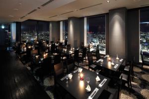 a restaurant with tables and chairs and a city skyline at The Westin Sendai in Sendai