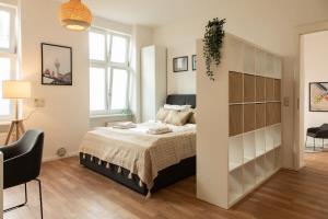a bedroom with a bed and a large book shelf at Luxuswohnung mit Kinozimmer im Herzen Berlins BY HOMELY in Berlin