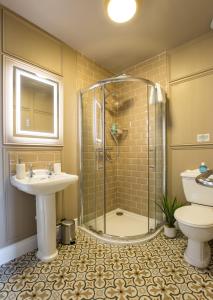 ein Bad mit einer Dusche, einem Waschbecken und einem WC in der Unterkunft Greystones Harbour Apartments in Na Clocha Liatha