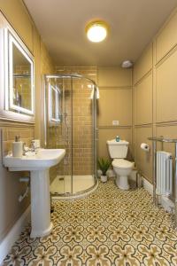 La salle de bains est pourvue d'un lavabo, d'une douche et de toilettes. dans l'établissement Greystones Harbour Apartments, à Na Clocha Liatha