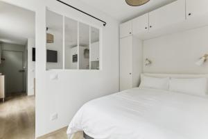a bedroom with white walls and a white bed at Paris 20 - rue Sorbier in Paris
