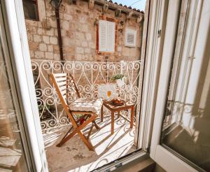 a balcony with a chair and a table at Mascheroni Luxury Rooms in Dubrovnik
