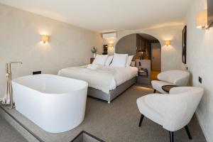 ブランケンベルヘにあるHotel Beach Palaceのベッドとバスタブ付きのホテルルーム