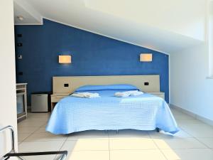 a blue bedroom with a bed with blue walls at Rooms&Apartments Hotel Danci in Borghetto Santo Spirito