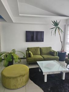 ein Wohnzimmer mit einem grünen Sofa und einem Couchtisch in der Unterkunft ForS Resort & Spa in Belgrad