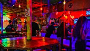 eine Gruppe von Menschen in einer Bar mit Neonlichtern in der Unterkunft Mantis and Moon Backpackers and Surf Hostel in Hibberdene