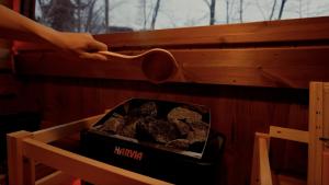 a person holding a wooden spoon over a box of rocks at Hakuba Hibiku Chalet by Jade Villa in Hakuba