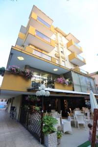 a building with tables and chairs in front of it at villa Anny in Rimini