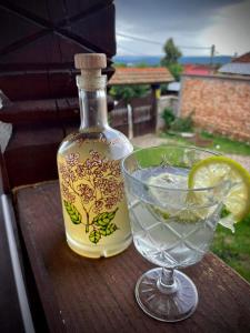a bottle of liquor and a glass of lemonade on a table at The Carpathian Lodge in Runcu