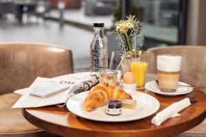 柏林的住宿－柏林庫達姆阿斯布里亞酒店，一张桌子,上面放着一盘羊角面包和两杯饮料