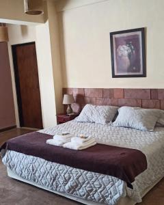a bedroom with a large bed with towels on it at Portal del Sol in San Ignacio