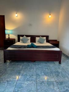 a bedroom with a large bed with two pillows at Natures Bliss Holidays in Ja-Ela