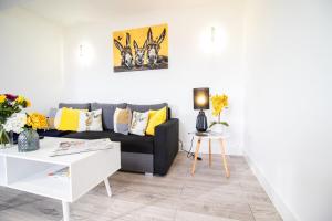 a living room with a black couch and yellow pillows at May Disc - Long Stay - Contractors in Swindon