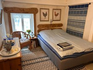a bedroom with a bed and a table and a chair at Savikulma savihuone B&B in Mynämäki