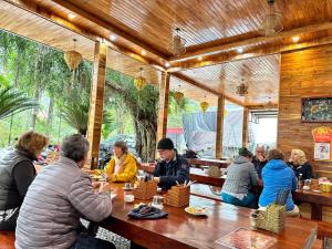 a group of people sitting at a table in a restaurant at Tam Coc Rocky Bungalow in Ninh Binh