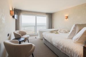 a hotel room with a bed and a large window at Hotel Beach Palace in Blankenberge