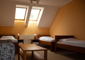 Pružina的住宿－Penzión pod Strážovom，客房设有两张床、一张桌子和两个窗户。