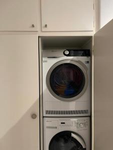 a washing machine and a washer in a cabinet at Bellezza in Lorraine in Bern