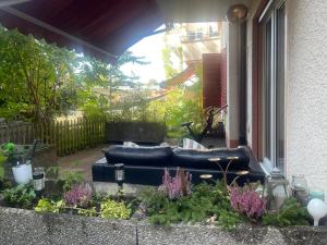 a patio with a black couch in a garden at Bellezza in Lorraine in Bern