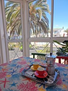 a table with two cups and a tea pot on it at Piccola Oasi in Corralejo