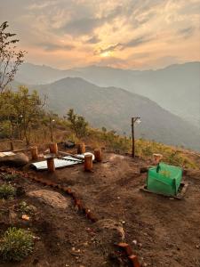vistas a una montaña con un cubo verde en Hide away valley en Kodaikānāl