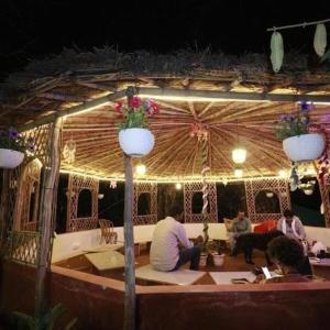 um grupo de pessoas sentadas num pátio à noite em The Roxxy Royal Resort em Rishikesh