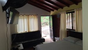a bedroom with a bed and a sliding glass door at Alojamiento Campestre Cabañas Mirador Ingrumá Riosucio Caldas in Ruiosucio