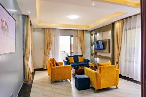 a living room with yellow chairs and a couch at Crown Elegance Suites in Kampala