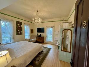 a bedroom with a white bed and a chandelier at The Ludington House in Ludington