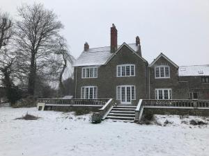 a large brick house with snow on the ground at Humphreston House in Temple Cloud