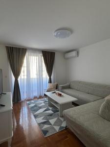 a living room with a couch and a coffee table at Apartment GeoMo in Mostar