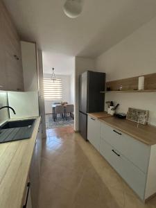 a kitchen with a refrigerator and a table at Apartment GeoMo in Mostar