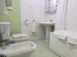 un bagno bianco con un water e un lavandino di Hotel & Restaurant White City a Berat