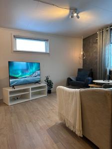 uma sala de estar com uma televisão de ecrã plano num suporte em Fin sentral leilighet i Lakselv! em Lakselv