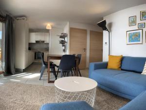 a living room with a blue couch and a table at Appartement Vars, 2 pièces, 6 personnes - FR-1-773-19 in Vars