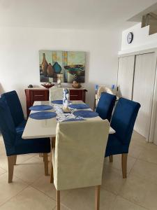 a dining room with a table and blue chairs at Departamento Frente al Mar -MANTA in Manta