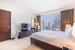 a hotel room with a large bed and a large window at Daniels 1BR at Address Marina High Floor with Marina View in Dubai