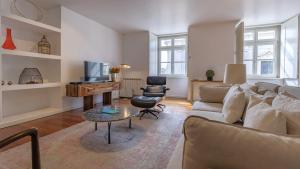 a living room with a couch and a table at LovelyStay - Chiado 3Bedroom Wonder in Lisbon