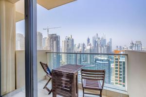 a balcony with a wooden table and two chairs at Daniels 1BR at Address Marina High Floor with Marina View in Dubai