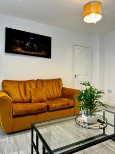 a living room with a brown couch and a glass table at Rooms Near Me - Apartment 2 Fast Wifi Smart Tv in Quinton