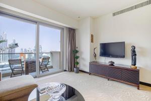 a living room with a couch and a tv at Daniels 1BR at Address Marina High Floor with Marina View in Dubai